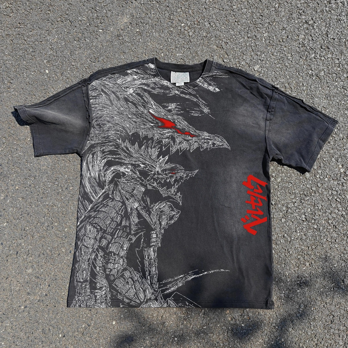 Black t-shirt with a graphic design of a creature and red text on a gray surface